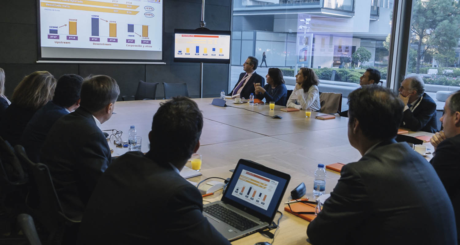 Meeting of people looking at a screen with statistics