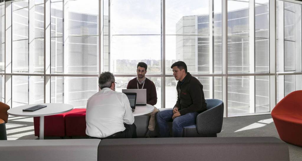 Three men sitting by a window