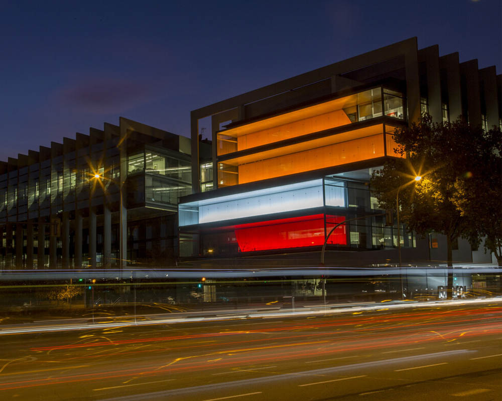 Repsol Campus at night with lights in the colors of the logo