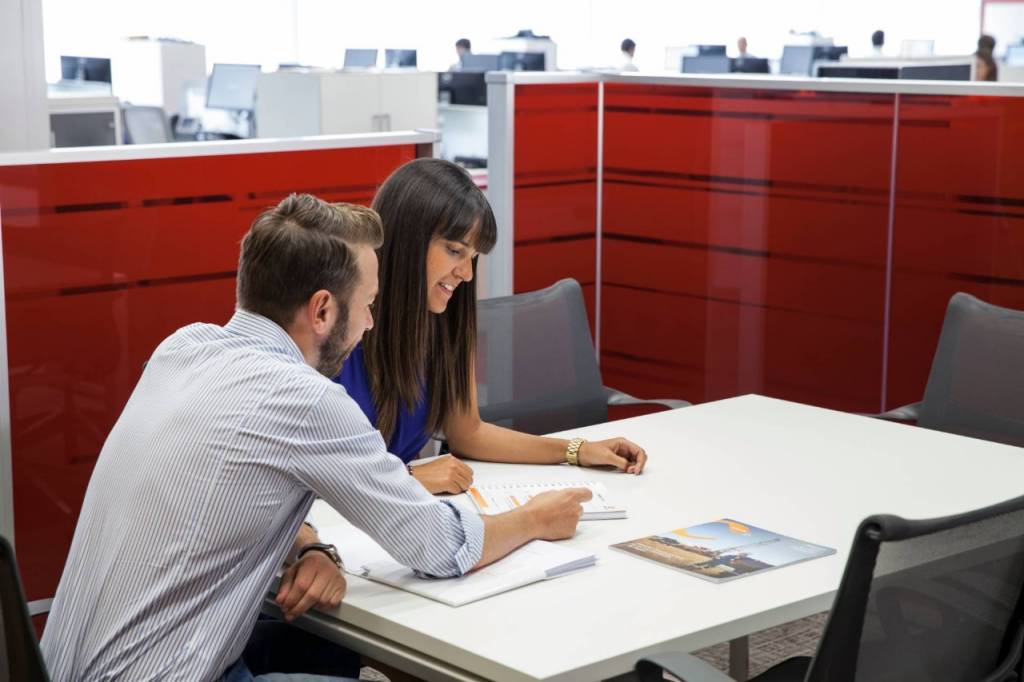 Two Repsol workers view a document