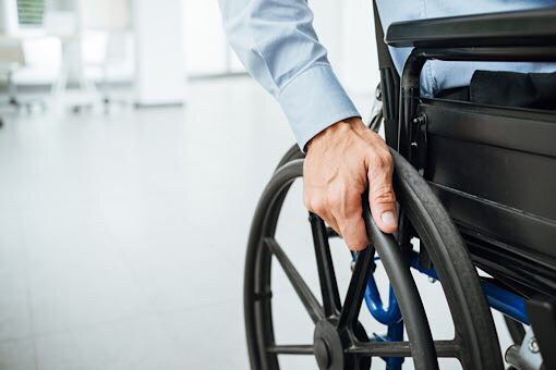 Close-up of a hand on a wheelchair. From Words to Actions paper