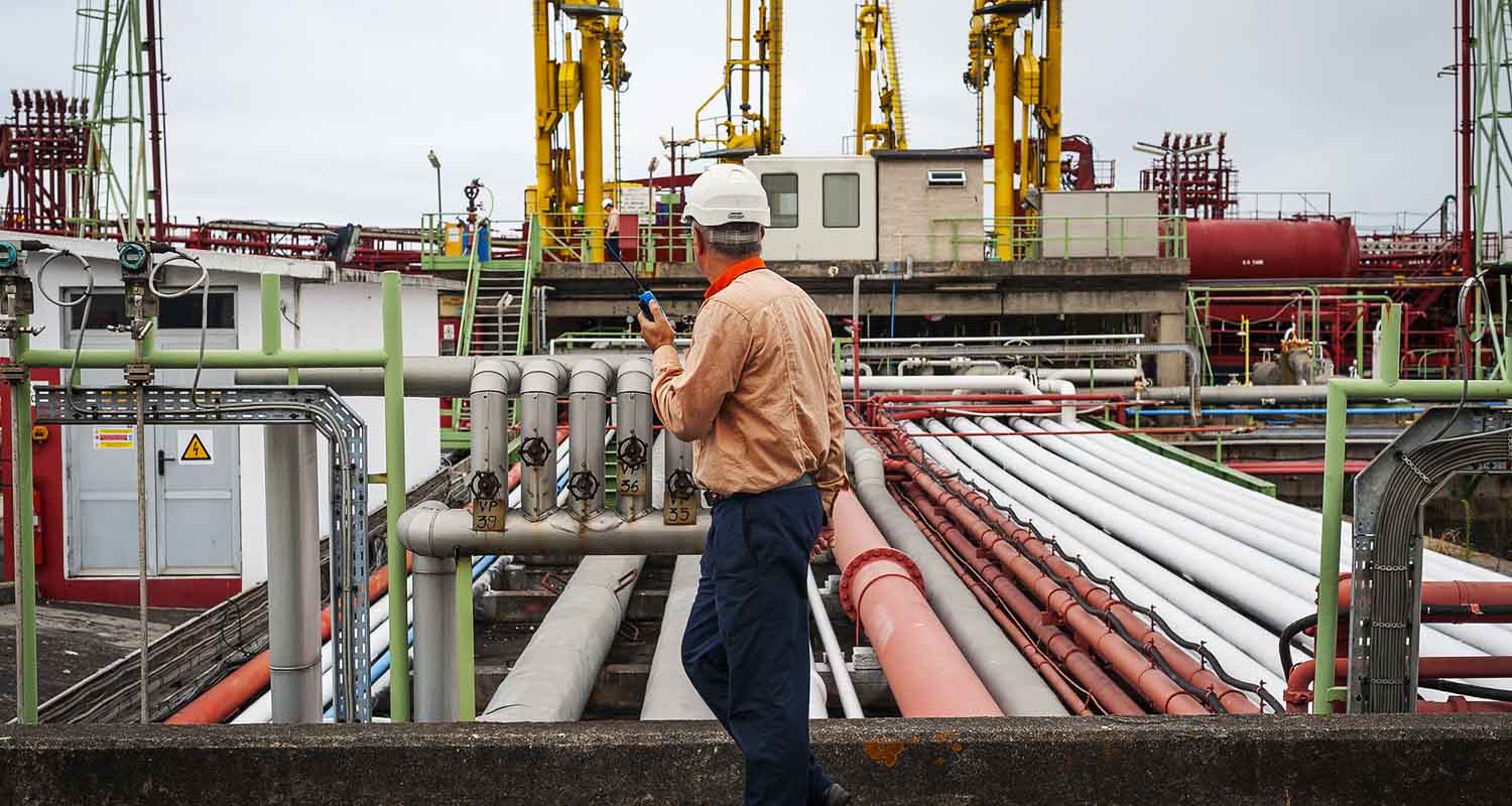 Operator talking on a walkie talkie at an industrial complex