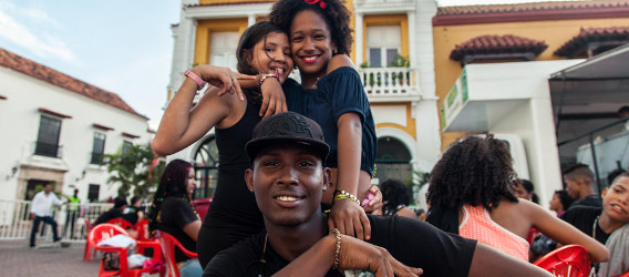 Un chico y dos chicas sonriendo. 