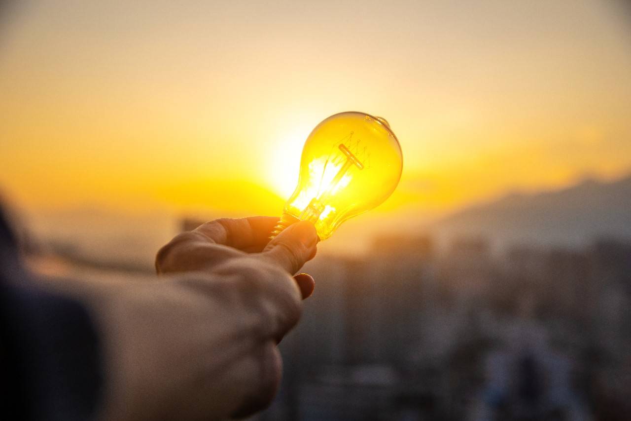 a light bulb with a sunset in the background