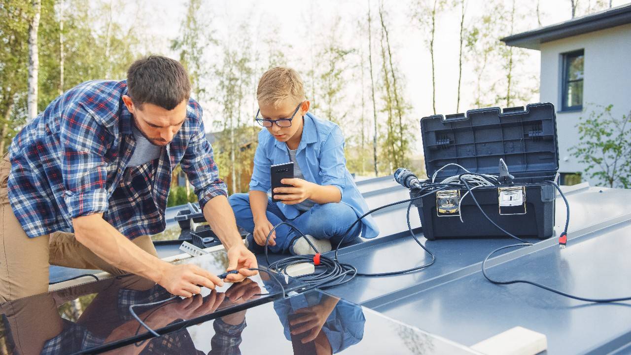 a father and his son connect solar panels